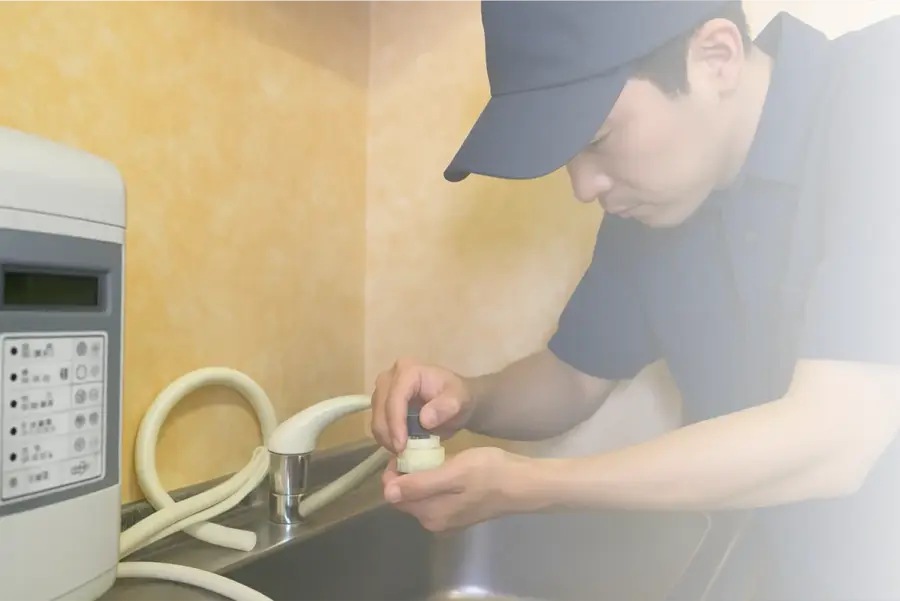 洗面所の配管を点検するスタッフ